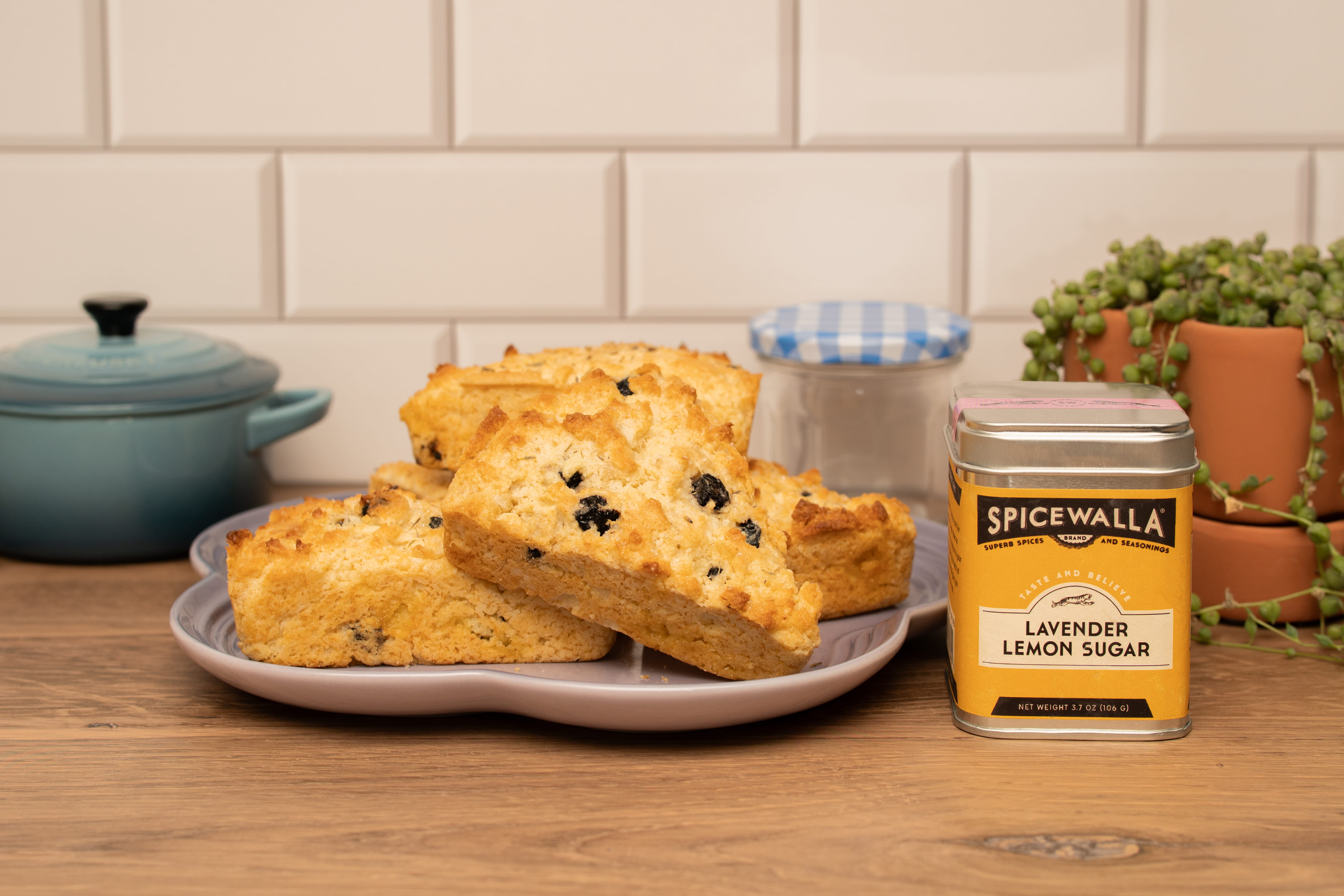 several scones sitting on a plate next to a container of sugar